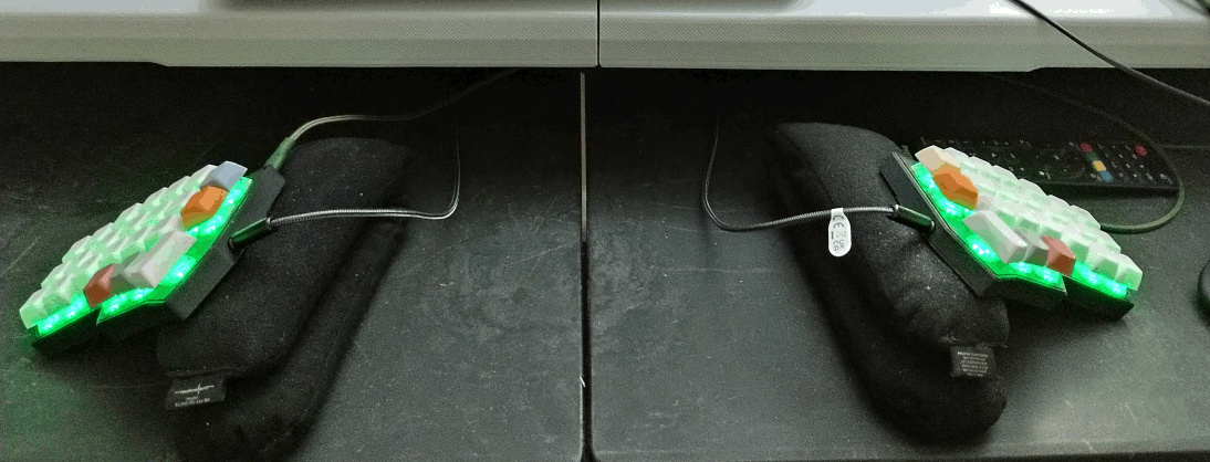 Picture showing both halves of keyboard. Each half is propped up with a folded bean bag wrist rest.